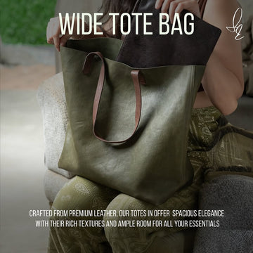 Person holding a green leather wide tote bag with text about the product's features.