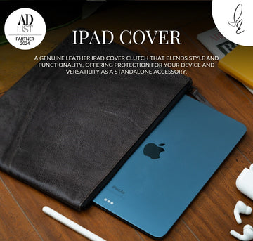 Grey leather iPad cover on a wooden surface with an Apple iPad and accessories.