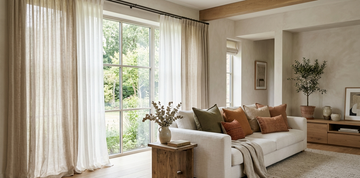 Luxury living room styled with Belgian linen curtains, neutral cushion covers, and a textured throw in soft natural lighting