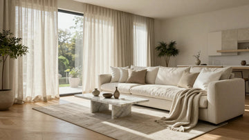 Luxury modern living room with Belgian linen curtains, neutral cushion covers, and a textured sofa throw blanket.
