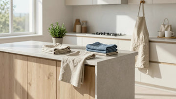 Minimalist kitchen decor with Belgian linen apron, kitchen towels, and reusable cotton shopping bags in neutral tones.