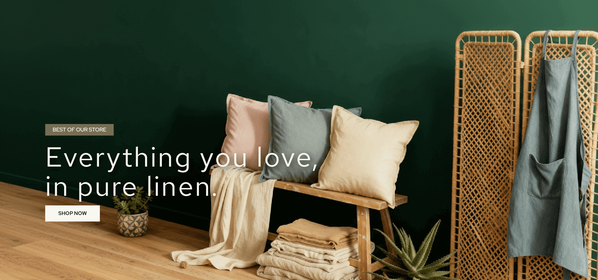 Pure linen products displayed on a wooden bench against a green wall.slider_item_Ti7z73