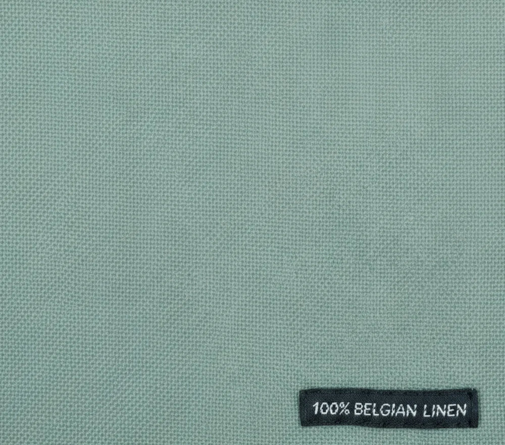 Textile with a '100% Belgian Linen' label on a light green background