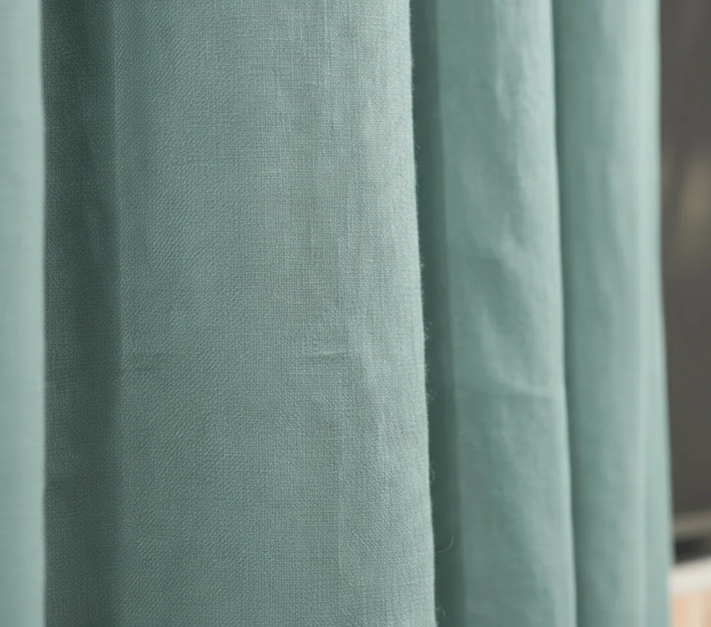 Close-up of teal curtains with a blurred background