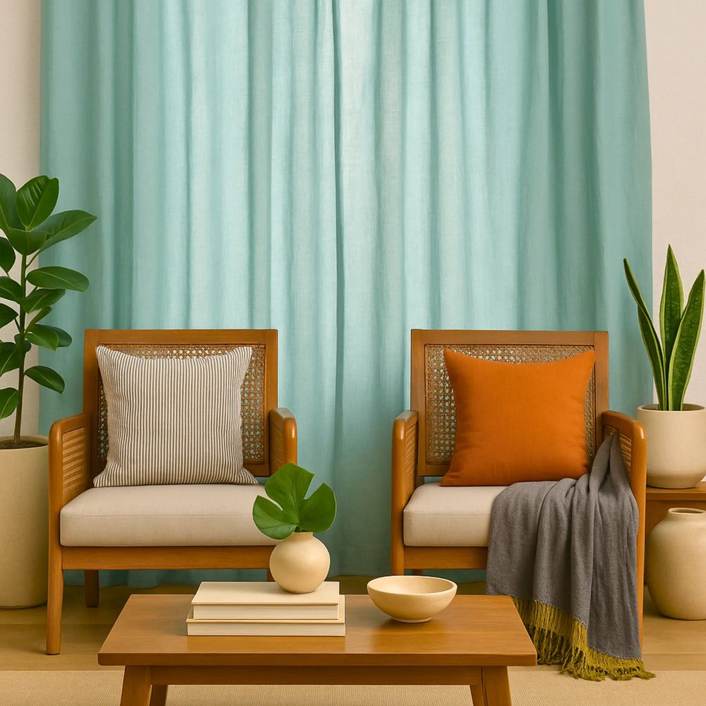 Two wooden chairs with cushions and a coffee table in a room with light blue curtains.