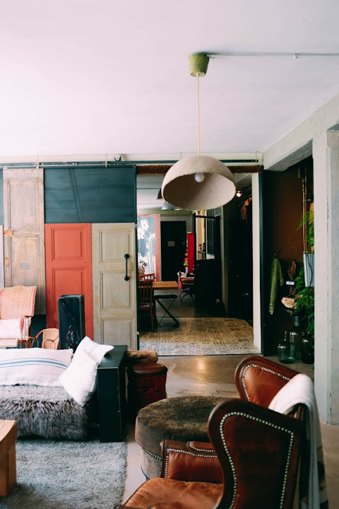 Living room with brown leather chairs, gray sofa, and colorful walls.