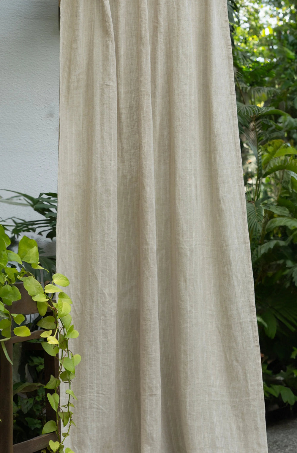 Beige curtain with green plants in the background