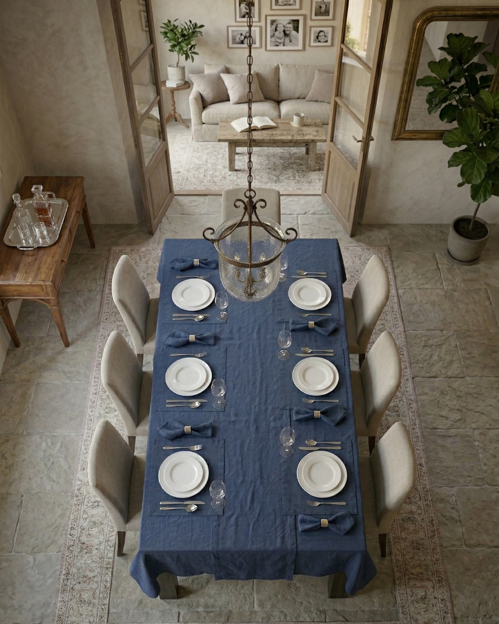 Dining room with a long table set for dinner, chairs, and a chandelier.