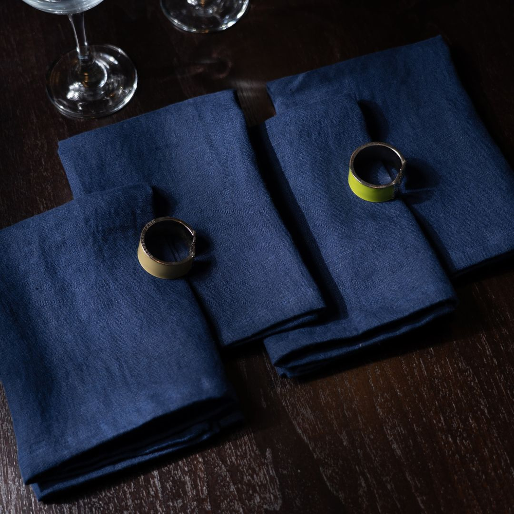 Blue napkins on a wooden table with two rings.