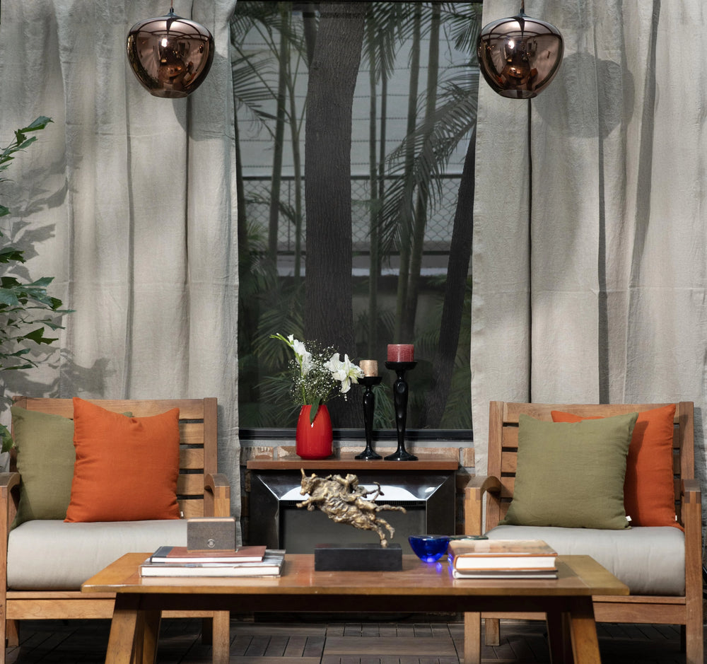 Outdoor seating area with wooden chairs, table, and decorative items against a neutral background.