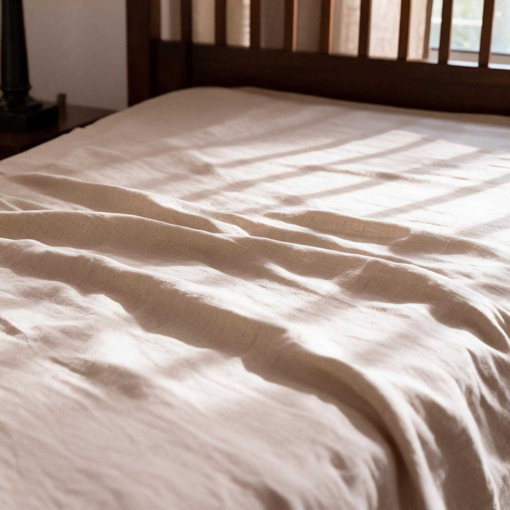 Flat lay of Natural Beige linen flat sheet set — one flat sheet and two pillowcases folded side by side on a cream background, showcasing the complete set in natural stonewashed linen