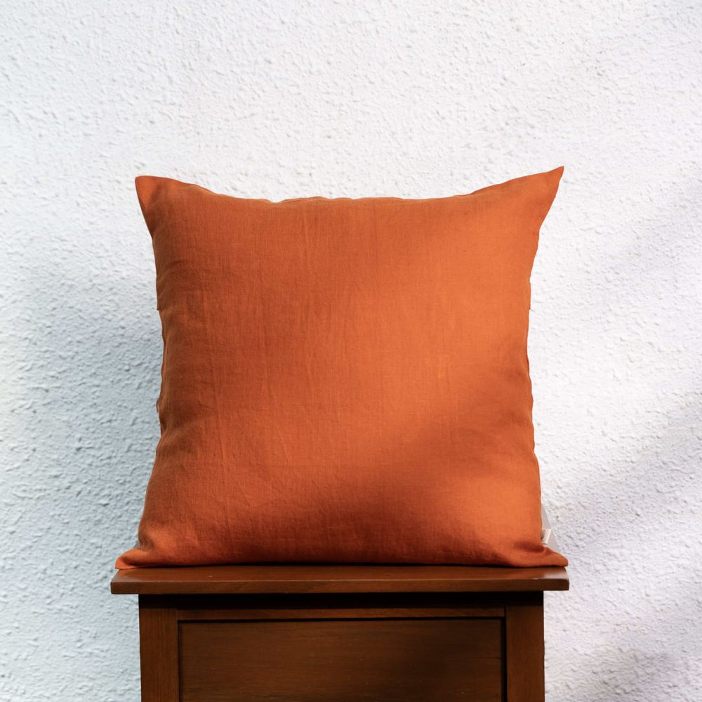 Rust Orange Linen Cushion Cover on a wooden table