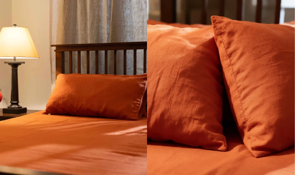 A bed dressed in rust-orange bedding with matching pillowcases, shown in a bedroom setting alongside a lit table lamp, with a close-up inset of the fabric texture.