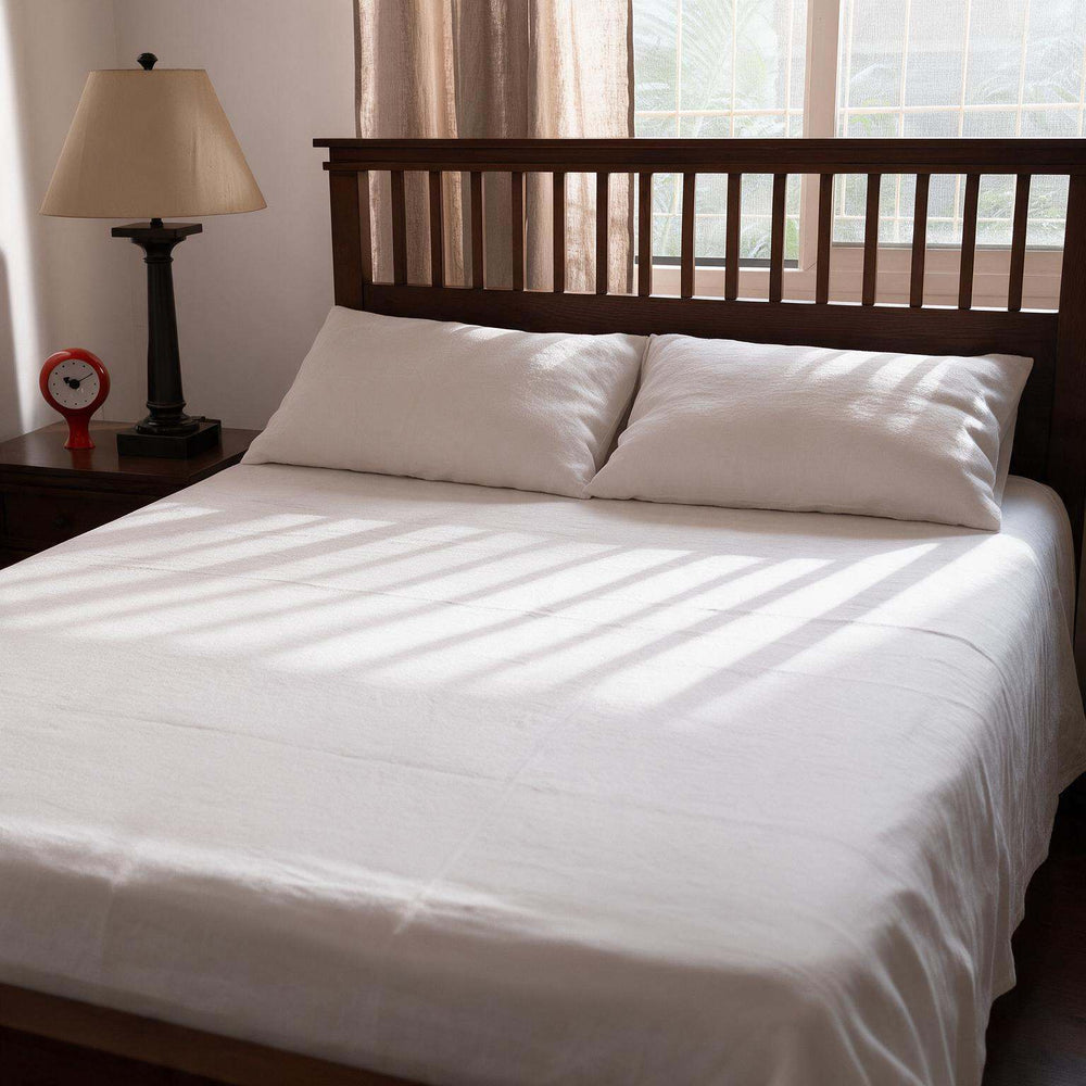Close-up of a white linen pillow cover casually propped against an oak headboard, showcasing the relaxed natural crinkle and soft linen texture in morning light