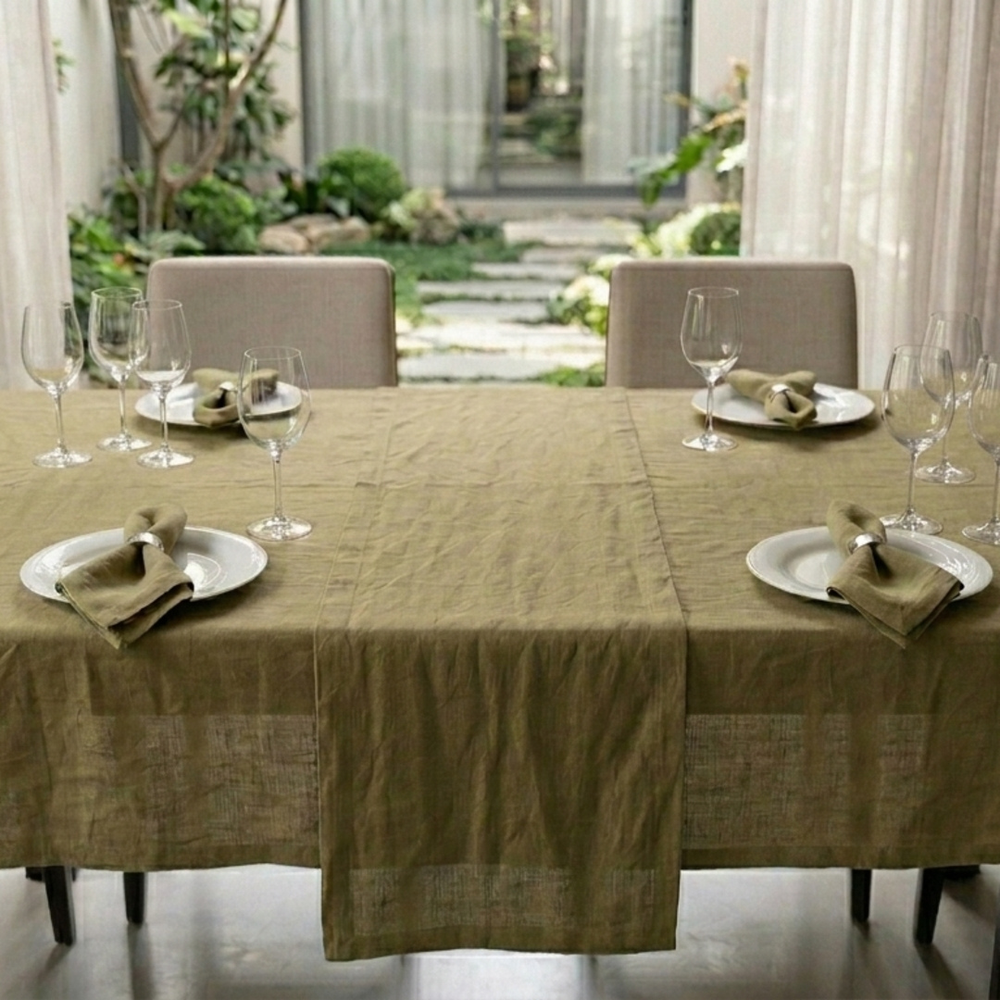 Dining table set with plates, glasses, and napkins in a room with large windows and outdoor view.