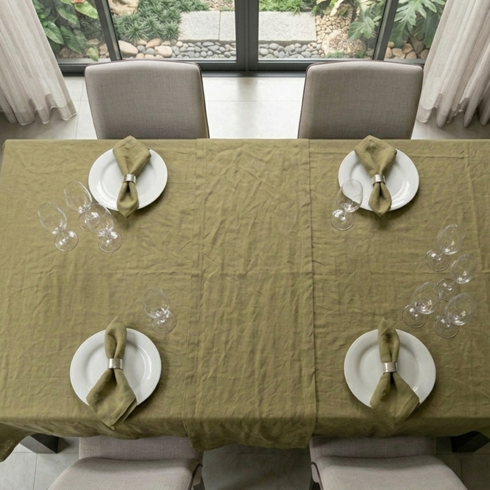 Dining table set with plates, napkins, and glasses on a green tablecloth.