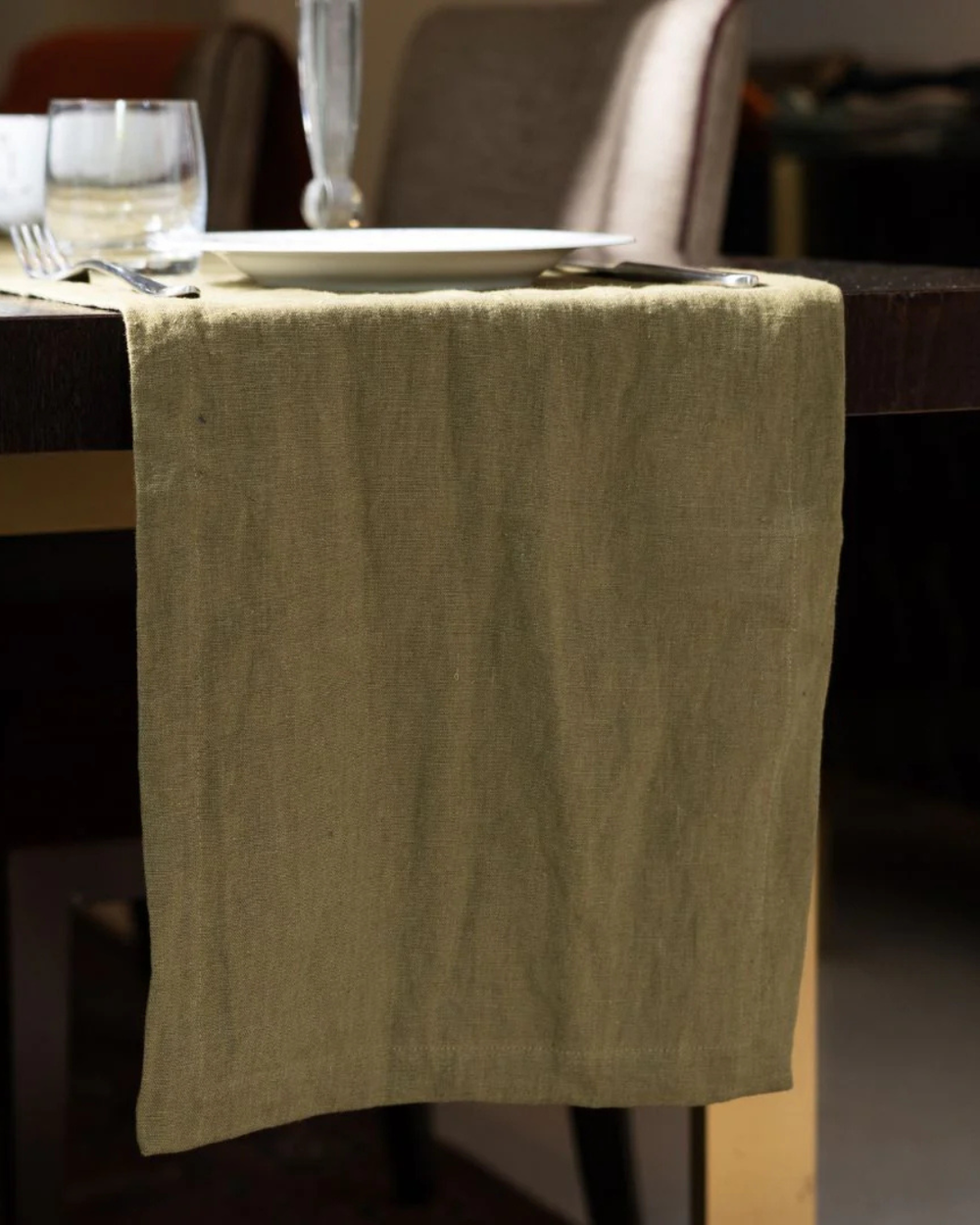 Green table runner on a wooden table with blurred background