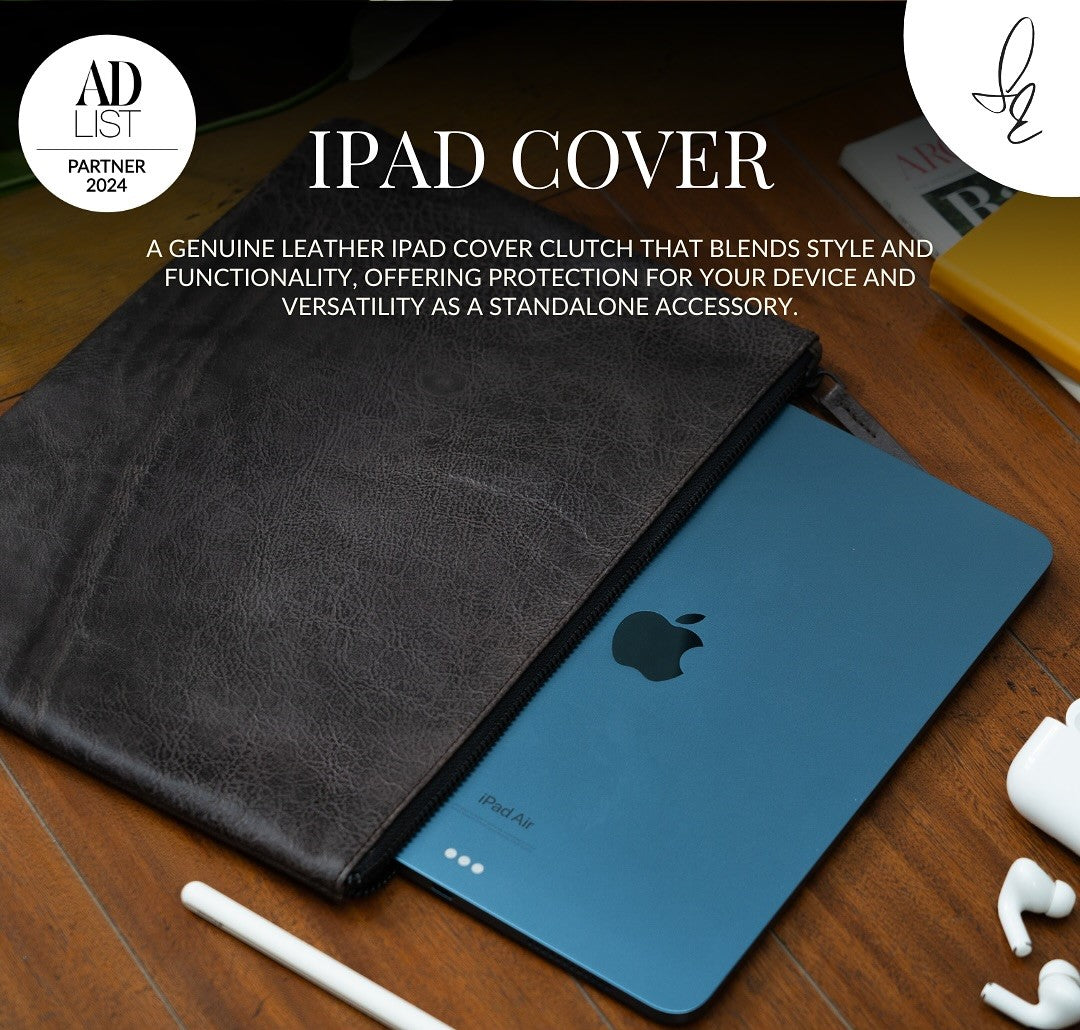Grey leather iPad cover on a wooden surface with an Apple iPad and accessories.