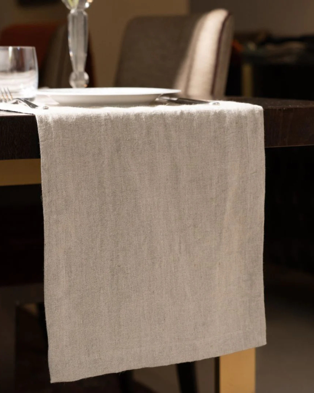Beige napkin draped over a chair at a dining table with a blurred background