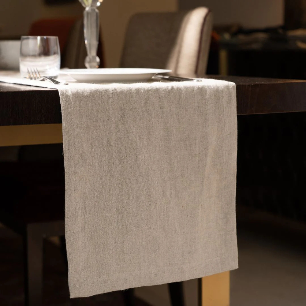 Beige table runner on a wooden table with blurred background