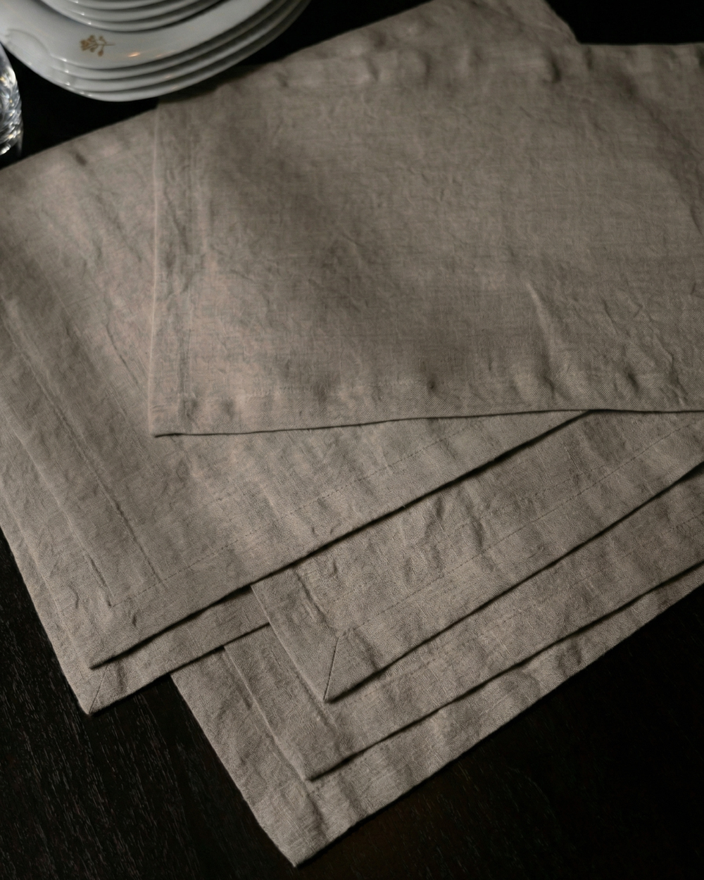 Set of gray placemats on a dark surface