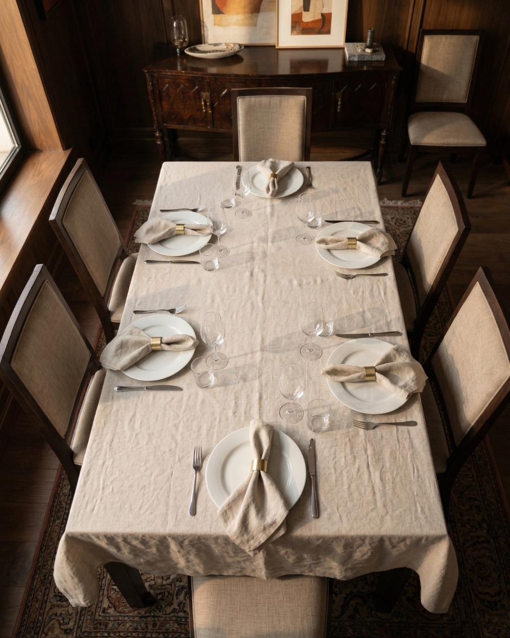 Dining table set with plates, glasses, and cutlery in a formal dining room.