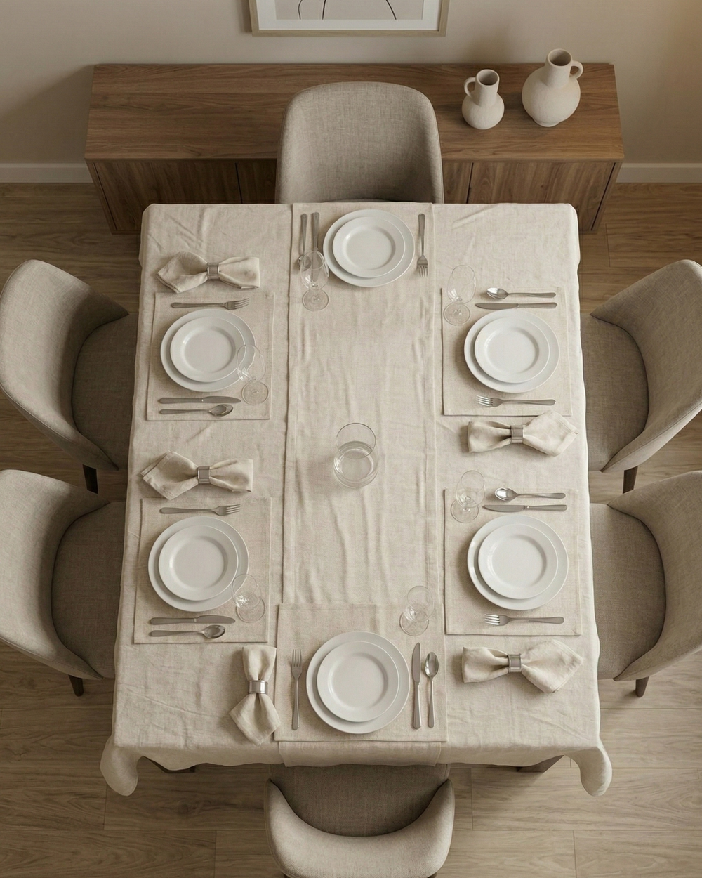 Dining table set with plates, cutlery, and napkins in a modern kitchen.
