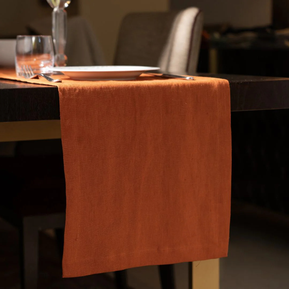 Orange table runner on a dark wooden table with a blurred background